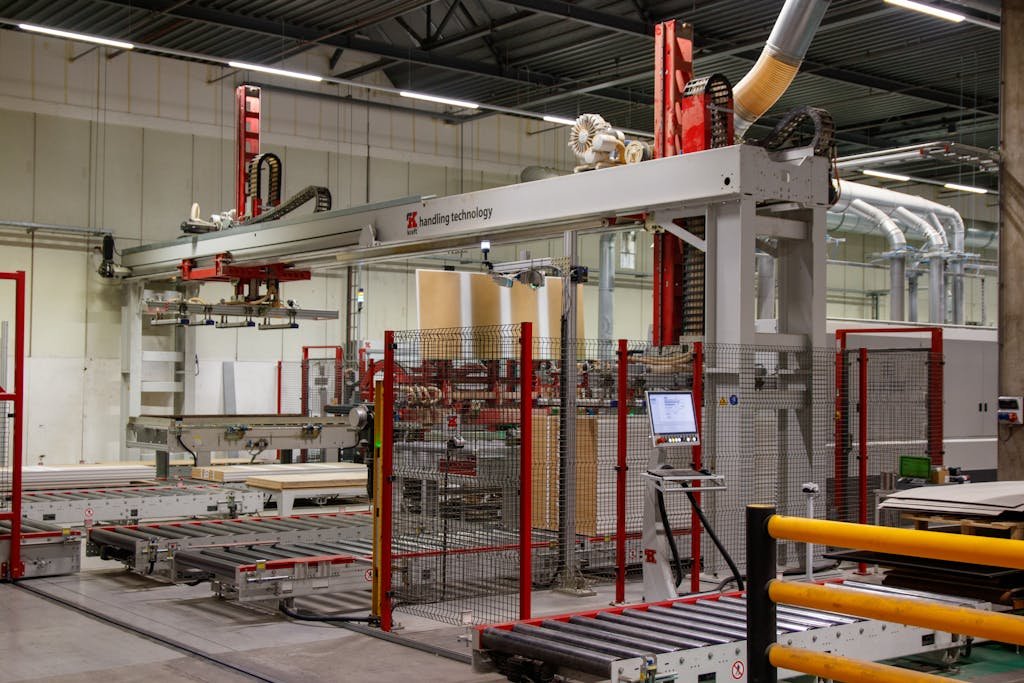 Industrial machinery with robotic arm in a modern manufacturing facility.